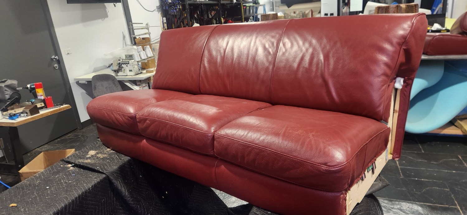 The restored red leather Natuzzi lounge after rewebbing and new foam